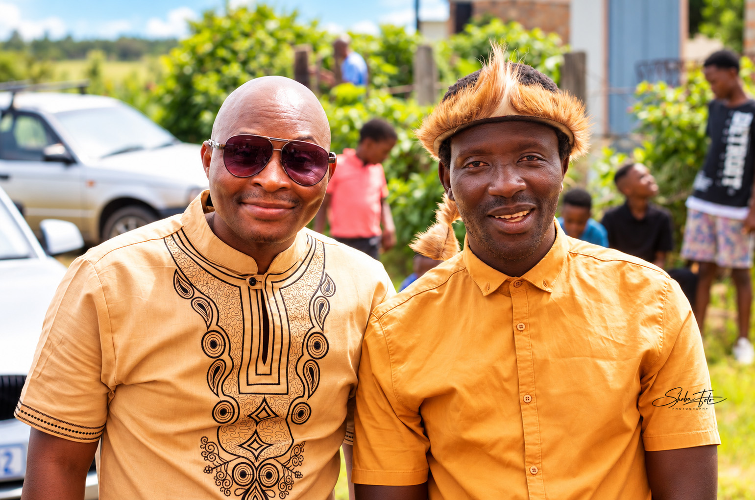 Two guests wearing gold shirts at an outdoor event